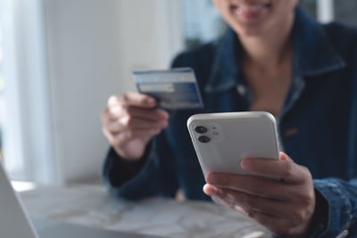Person holding credit card and smartphone