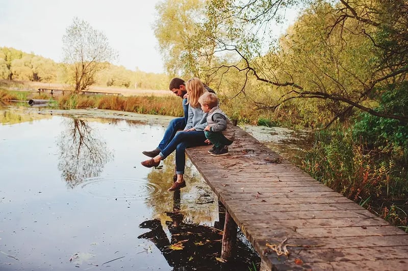 Couple sitting near a pond.