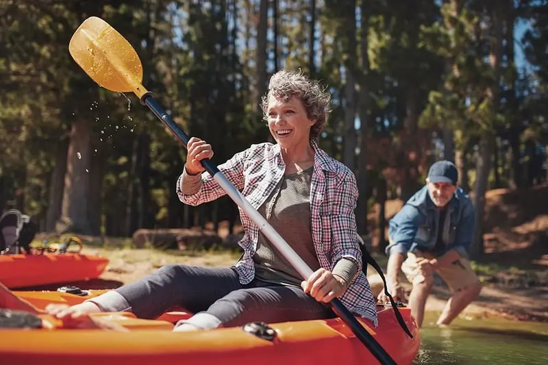 Senior woman paddling a kayak.