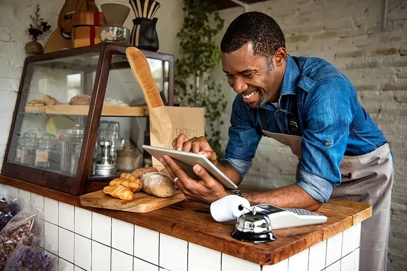 Man in a bakery working on a digital tablet.