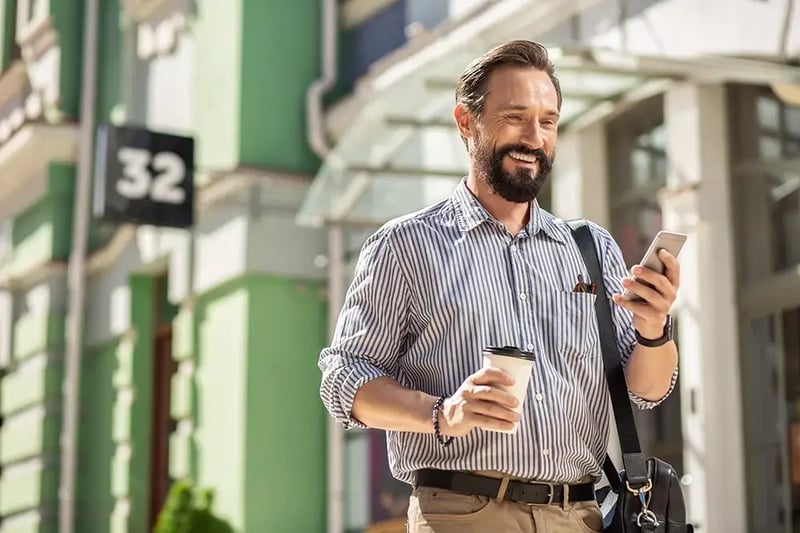 Man on a city street with a cell phone.