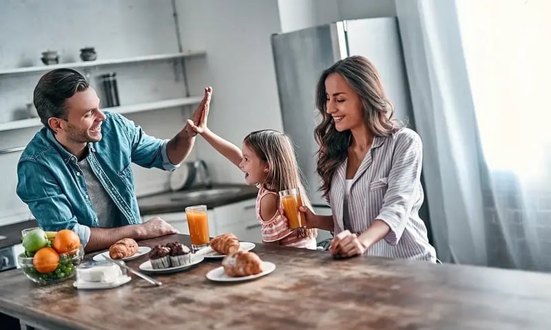 Happy family at a breakfast table.