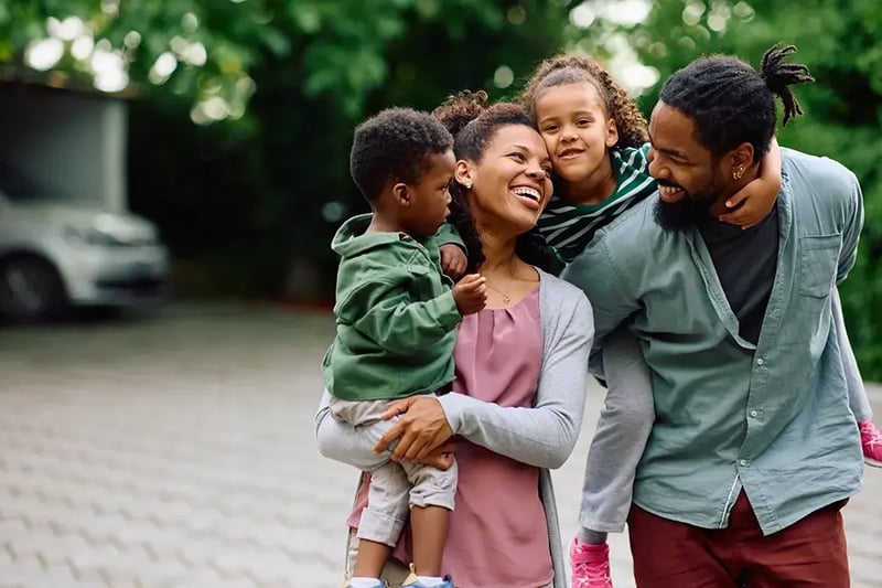 Happy family walking in a driveway.
