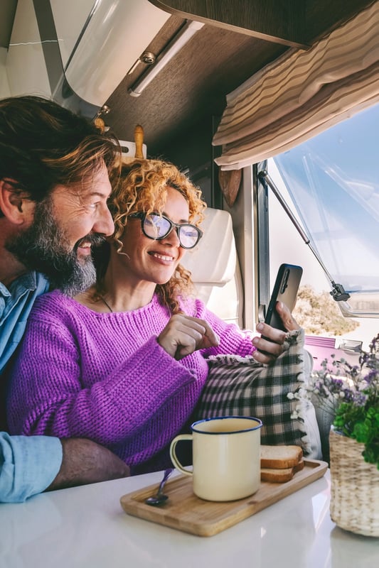 Couple in RV looking at a cell phone.