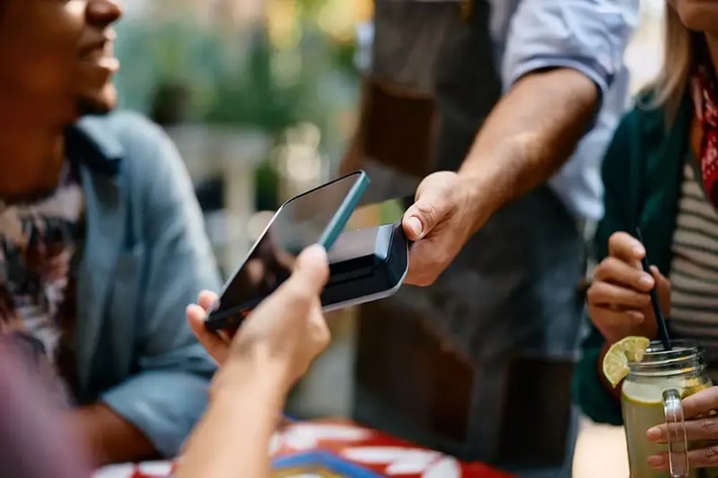 Person using cell phone to tap to pay.