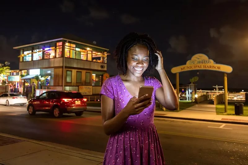 Woman looking at a cell phone at night.