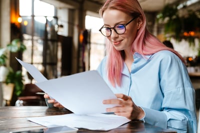 Woman looking at paperwork at a desk.