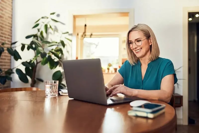 Woman sitting at a desk with a laptop computer.
