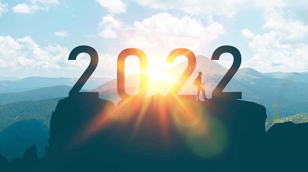 A mountain top background with silhouette of a hiker and the number "2022" centered on top of the mountain