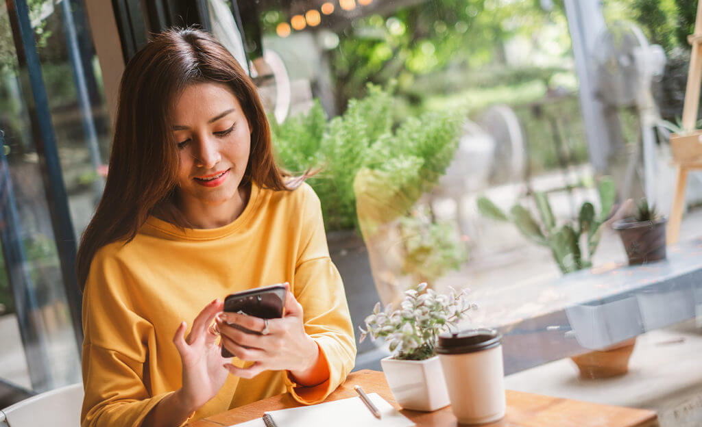 Youngwoman using smart phone for business