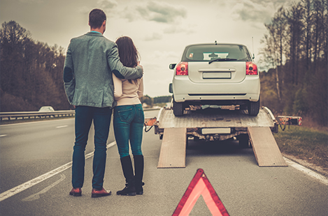 Couple watching as car is towed away