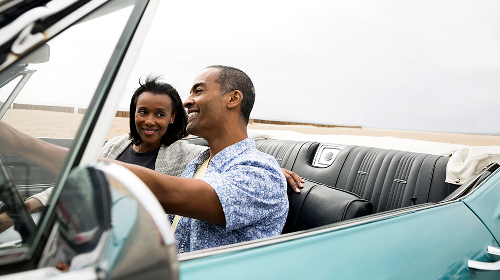 Couple riding in a blue classic convertible