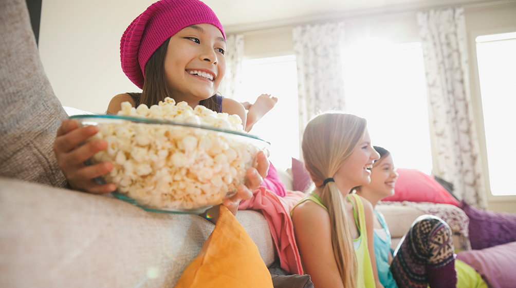 Family at home watching movies and eating popcorn