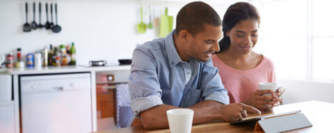 young-couple-finances-tablet-kitchen