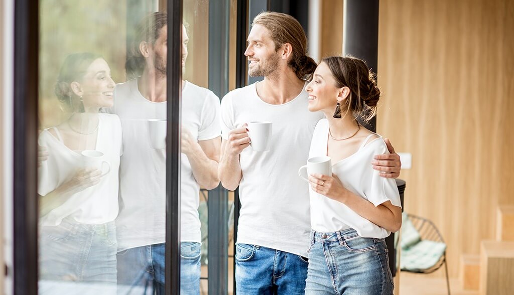 Couple looking out window while drinking coffee