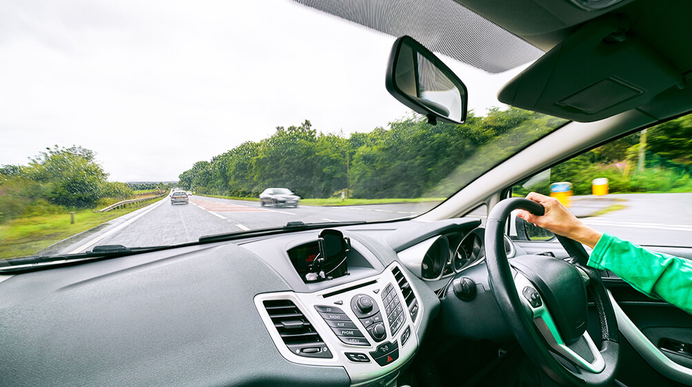 first person view behind the passenger seat of car driving down an open road