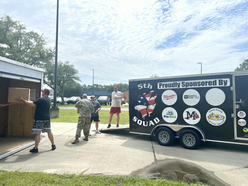 Men transferring donations from trailer