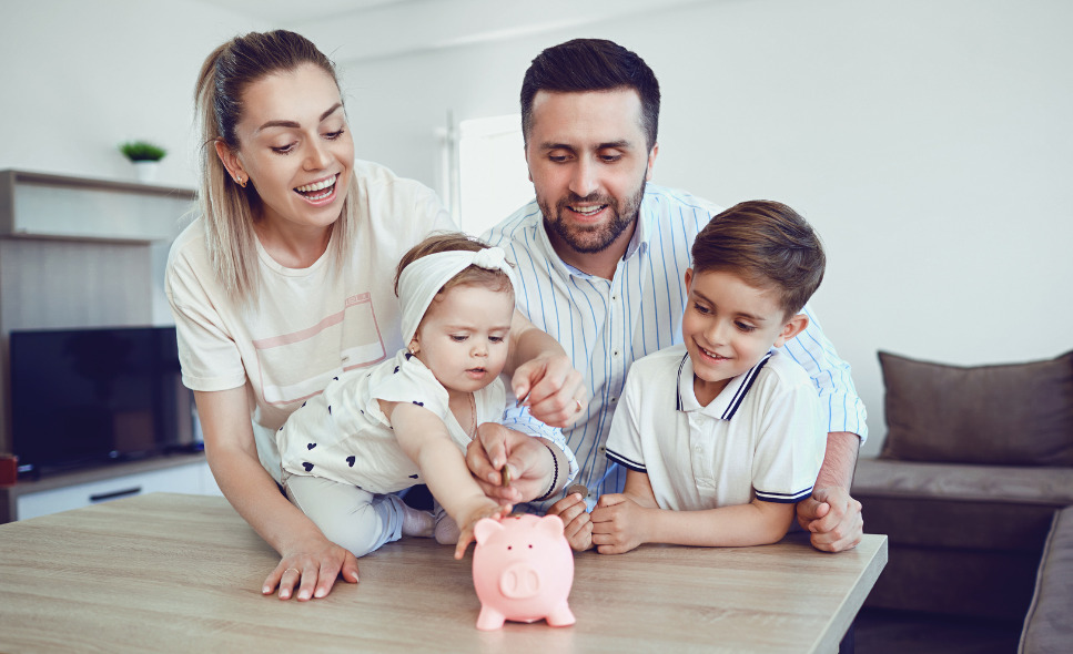 mom, dad and two kids putting money in a piggy bank