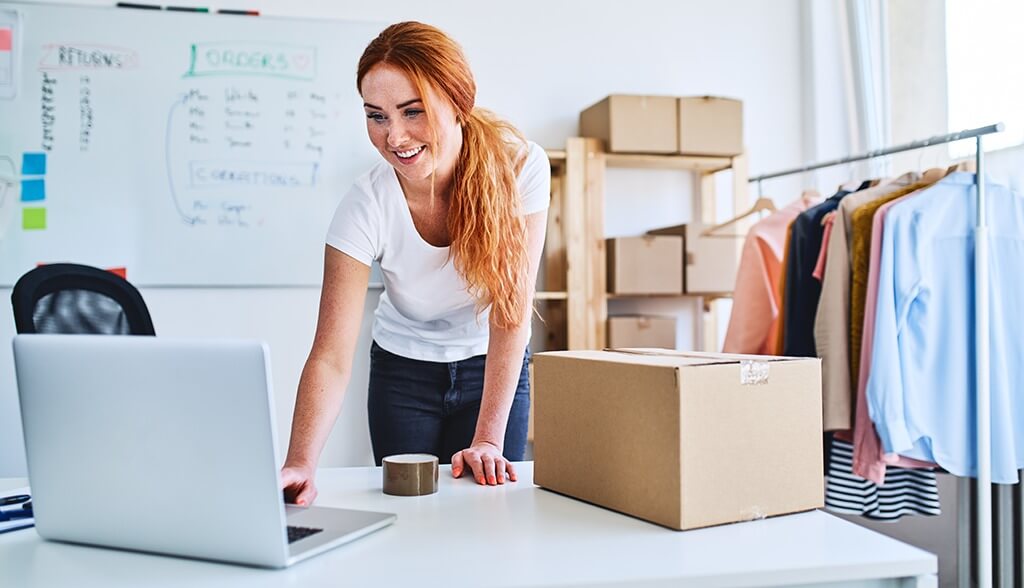 Red haired woman working on a laptop